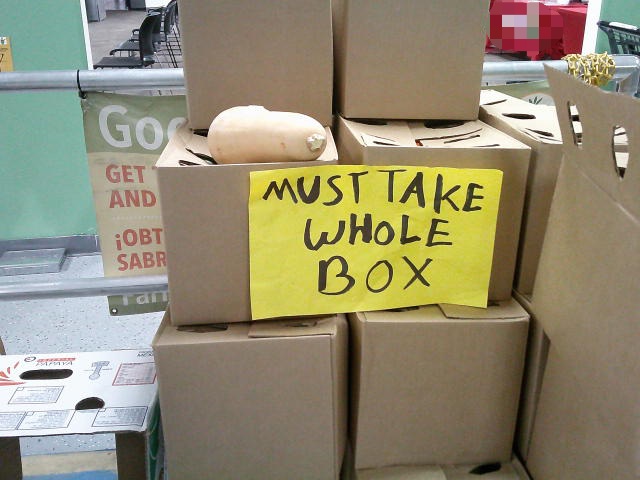 Boxes of produce with a sign that lists they must take the whole box.
